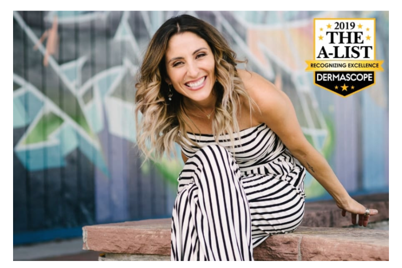 Woman in a striped outfit sitting on a bench with a '2019 A-List' Dermascope award above her.